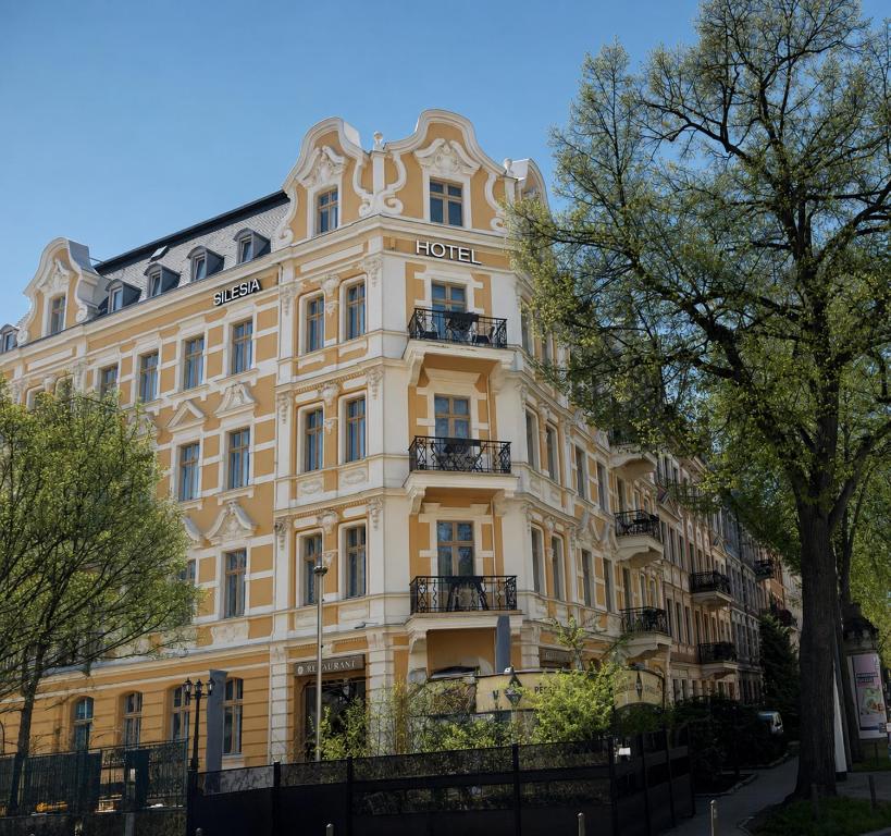 a large yellow building with a sign on it at Hotel Silesia in Görlitz