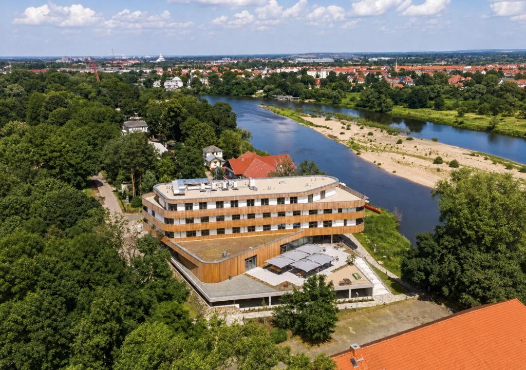 an aerial view of a building next to a river at Das ELB Hotel & Restaurant in Magdeburg