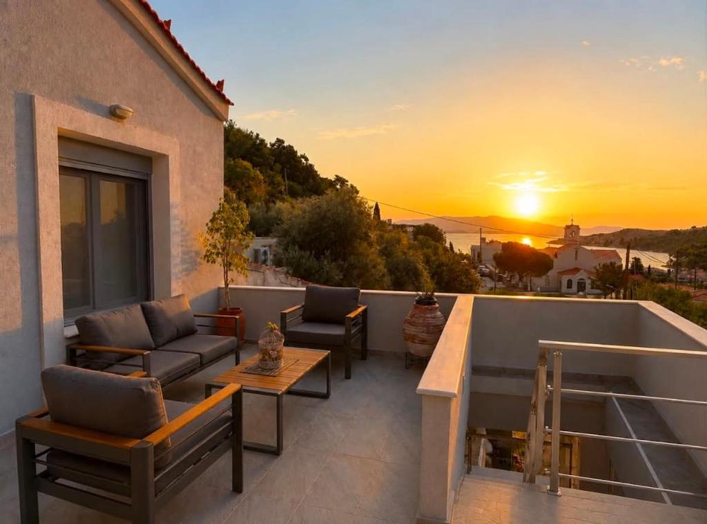 a balcony with couches and a sunset on a building at Paul's Horizon in Chios