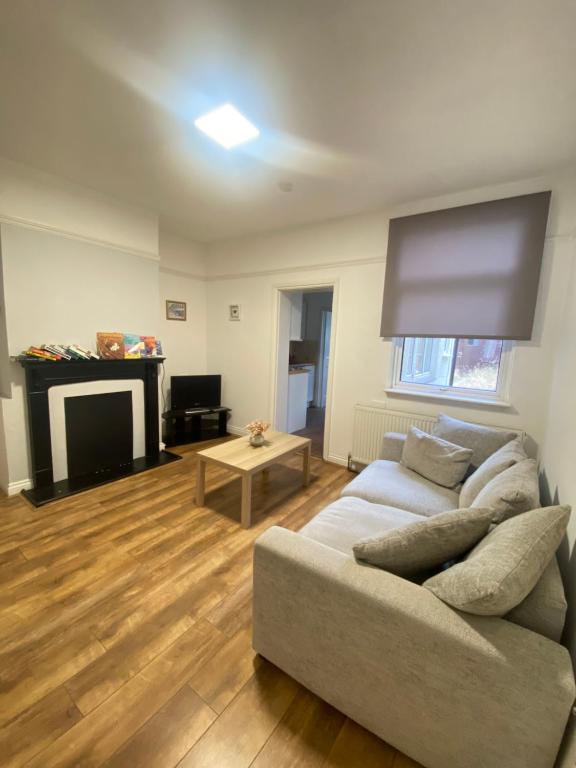 a living room with a couch and a fireplace at The Nest Chelmsford in Chelmsford