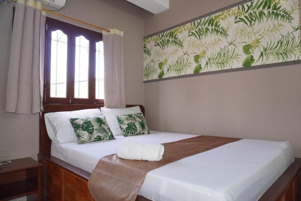 a bedroom with a bed with white sheets and a window at Hotel Lua y Origenes Santa Marta in Santa Marta