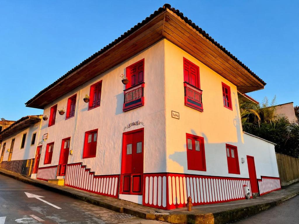 a building with red doors and windows on a street at Hostal Tralala Salento in Salento