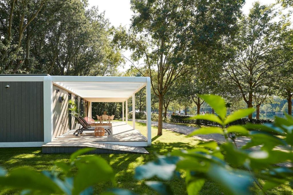 a pavilion with a table and chairs in a yard at Forest Cube 4 persons #706 in Maasbree