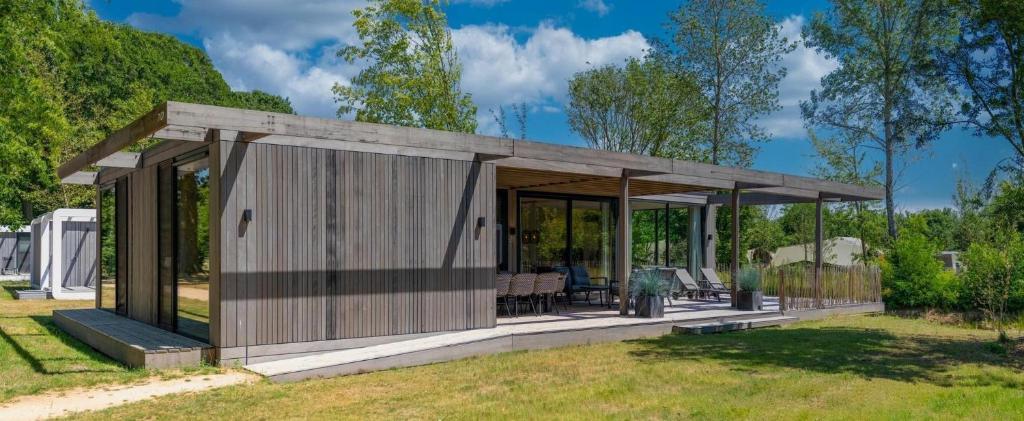 a wooden pavilion in a garden with trees at Forest Villa 6 persons #1212 in Maasbree