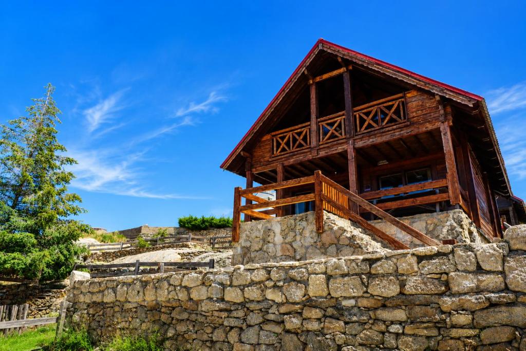 a wooden building on top of a stone wall at Chalet O Refúgio 3 in Penhas da Saúde