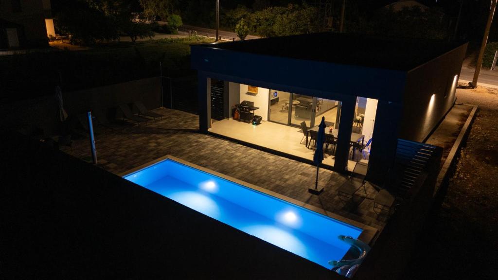 an overhead view of a house with a swimming pool at night at Villa Kleopatra in Međugorje