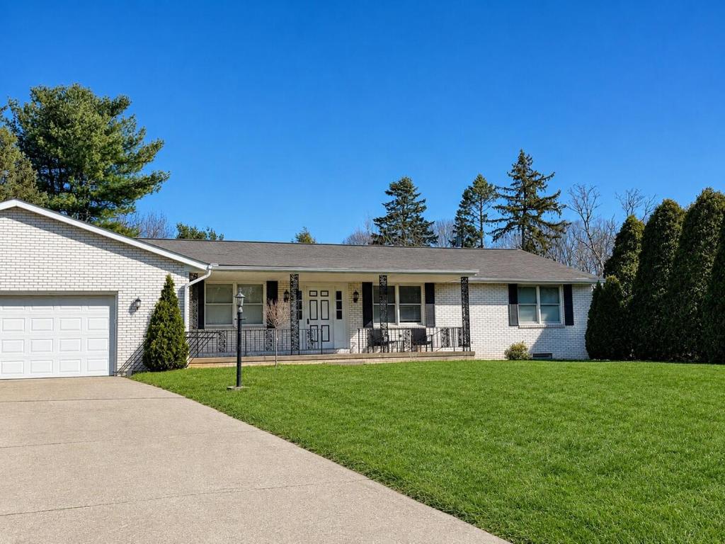 a white house with a lawn and a driveway at The Massillon Retreat! in Massillon