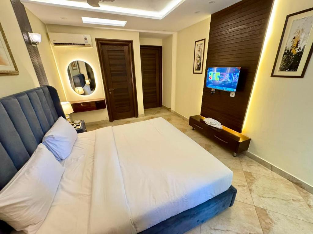 a bedroom with a bed and a flat screen tv at Bella Boutique Hotel Near Centaurus Mall - LMY Hospitality Islamabad in Islamabad