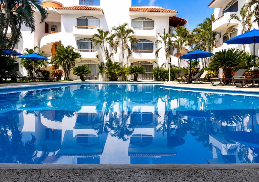 a swimming pool in front of a hotel at Dpto Exclusive Ixtapa in Ixtapa