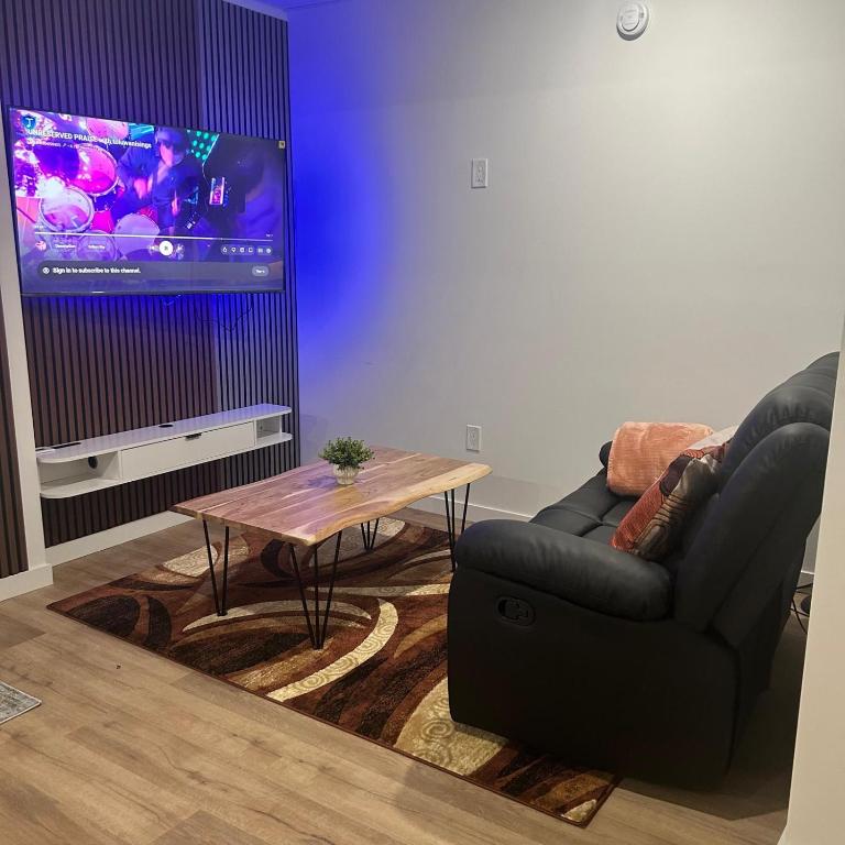 a living room with a couch and a table and a tv at AYBAM's House in Winnipeg
