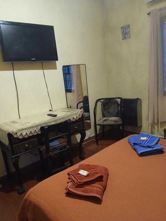 a bedroom with a bed with a mirror and a piano at Casa amigable dos habitaciones cuatro lugares in Rosario