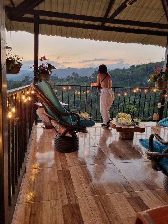 a woman standing on a balcony looking at the view at Alojamiento Las Rocas in Confines
