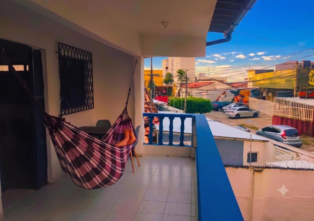 a hammock on a balcony with a view of a street at Armorial Hostel in João Pessoa
