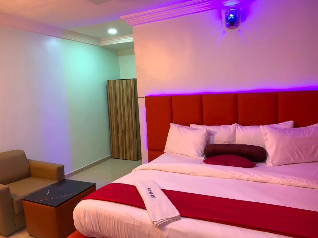 a bedroom with a large bed with a red headboard at Diamond Groove Hotel & Suites in Sangotedo