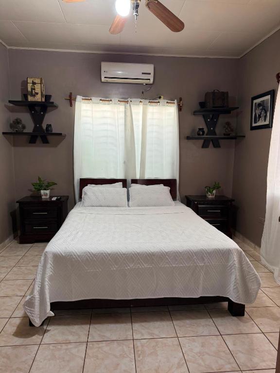 a bedroom with a bed with a white comforter at Hospedaje Ejecutivo Toronjal II in La Ceiba