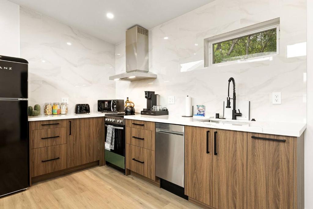 a kitchen with wooden cabinets and a black refrigerator at Spacious 1BR 1bath near DTLA in Los Angeles