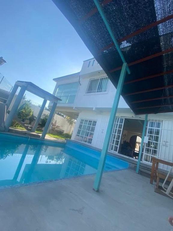 a swimming pool in front of a house at Quinta Kendriel in Tezoyuca