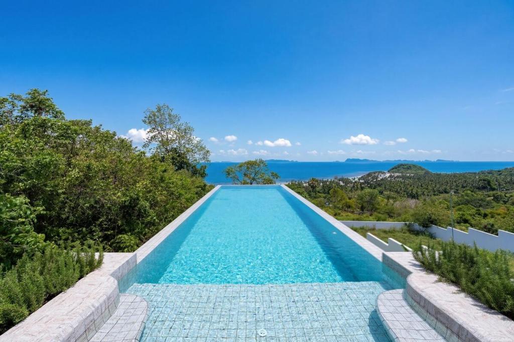 a swimming pool with a view of the ocean at Mee Kham Sook Luxury Villa in Nathon Bay