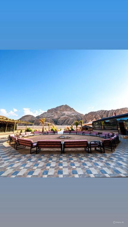a group of benches sitting on a patio with mountains in the background at Mirthe rum in Disah