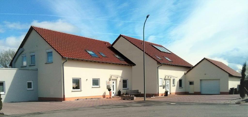 um grande edifício branco com um telhado vermelho em Ferienwohnungen Bella Vita em Harthausen