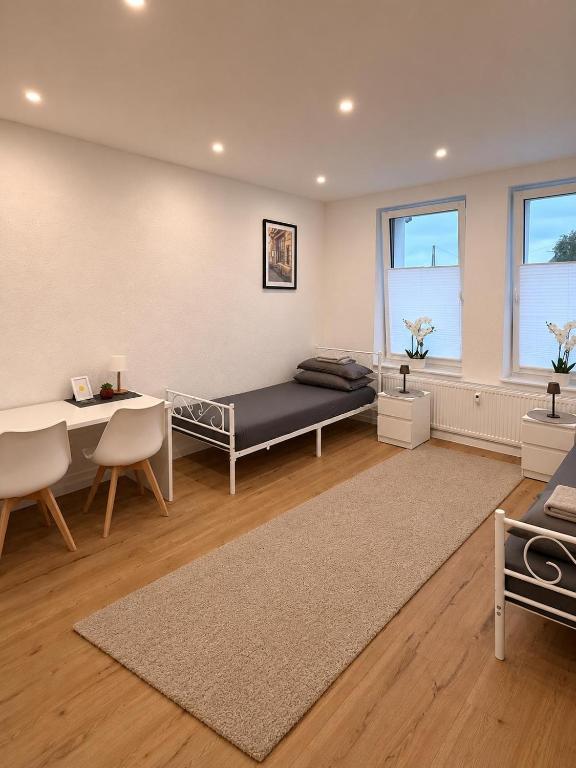 a bedroom with a bed and a desk and a table at H&R Suite - Bielefeld Central in Bielefeld