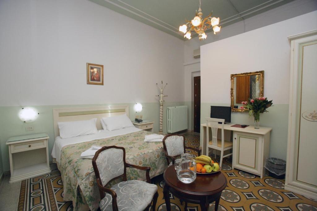 a hotel room with a bed and a table and chairs at Hotel Desirèe in Florence