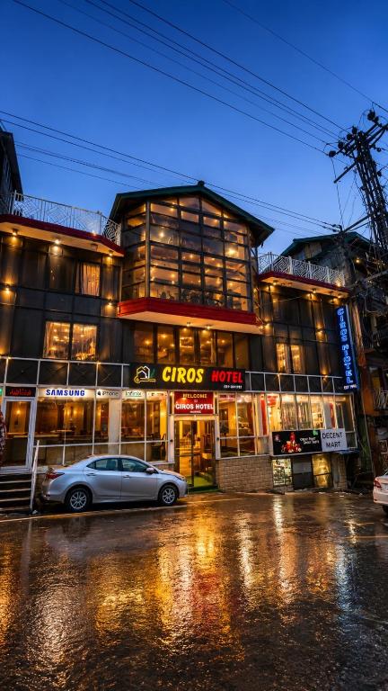 a car parked in front of a building at night at Mall Rd Murree Ciros Hotel in Murree