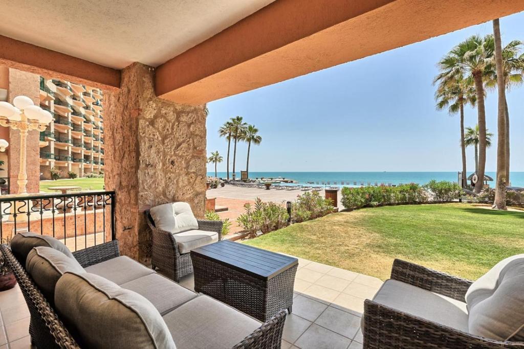 a patio with chairs and a table and the beach at Ground Floor Sonoran Sea 112-W in Puerto Peñasco