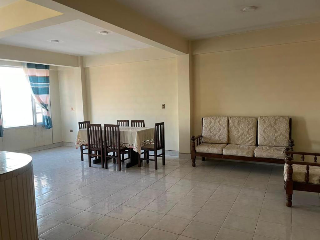 a dining room with a table and chairs and a couch at Maria's Place in Quillacollo