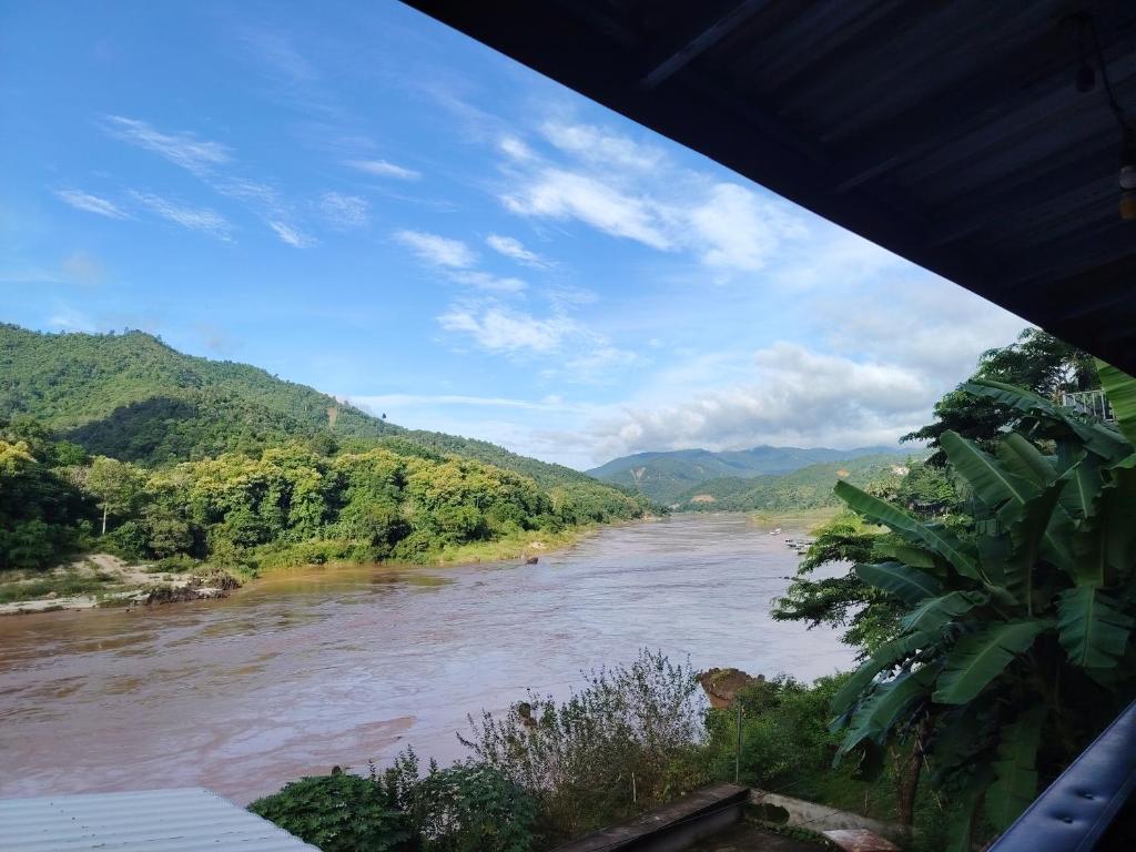 a view of a river with mountains in the background at Pakbeng Backpackers in Pakbeng