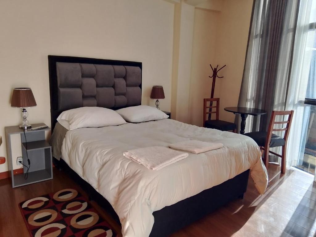 a bedroom with a large bed with two towels on it at Casa Sajama 121 in La Paz