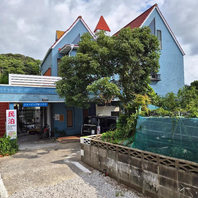 a blue house with a tree in front of it at 대마도쇼핑구마에하우스 in Tsushima