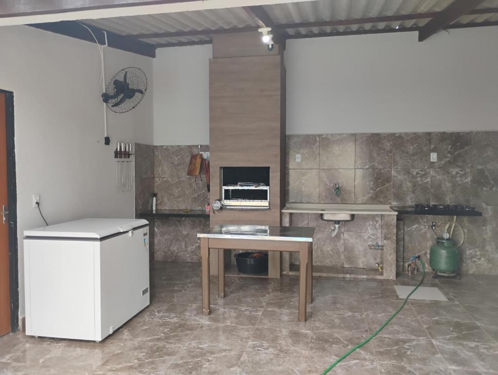 a room with a desk and a table in a room at Pousada Chapéu do Sol in Várzea Grande