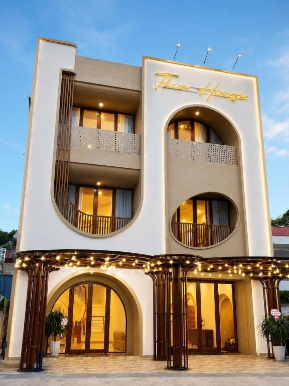 a large white building with lights on it at TherHouse in Mộc Châu