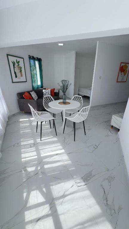 a white living room with a table and chairs at my house on the upper beach in Villas del Mar