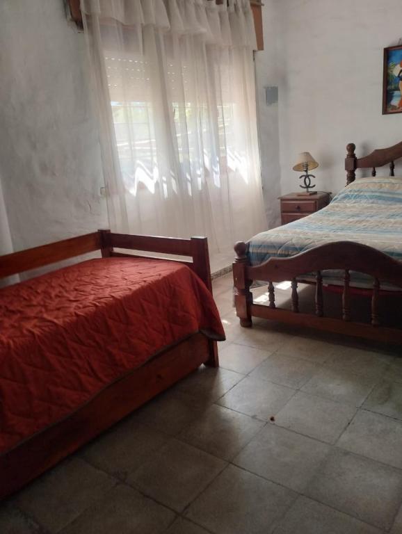 a bedroom with two beds and a window at Casa con bajada al rio in Villa Cura Brochero