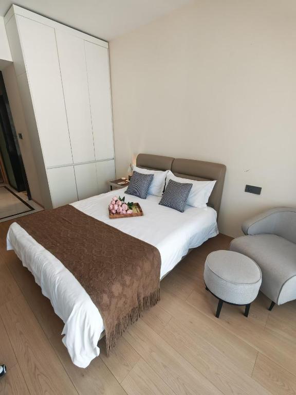 a bedroom with a large bed and a chair at 城绩公寓 in Phnom Penh