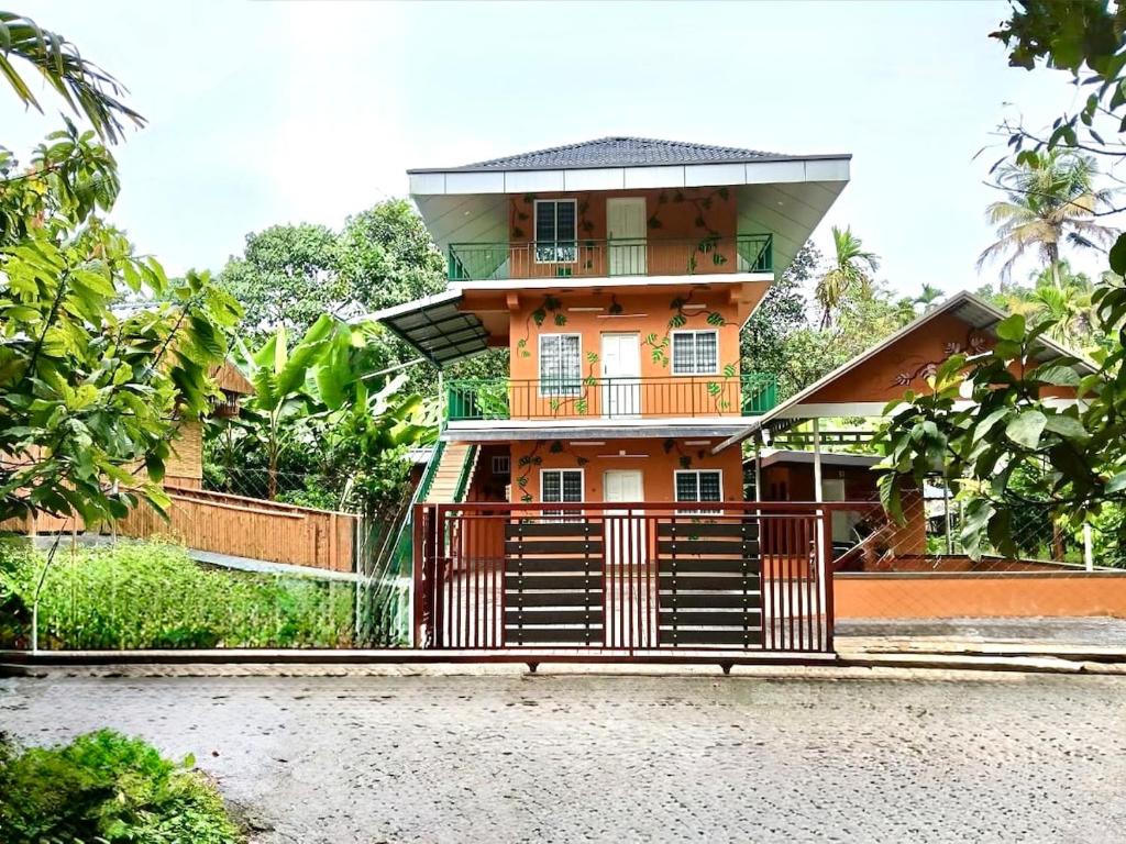 a house with a tower on top of it at Fruits Garden Resort in Kotamangalam