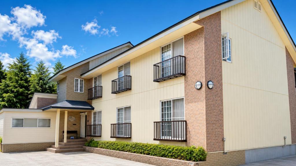 an apartment building with balconies and trees at Villa Rengatei in Hakuba