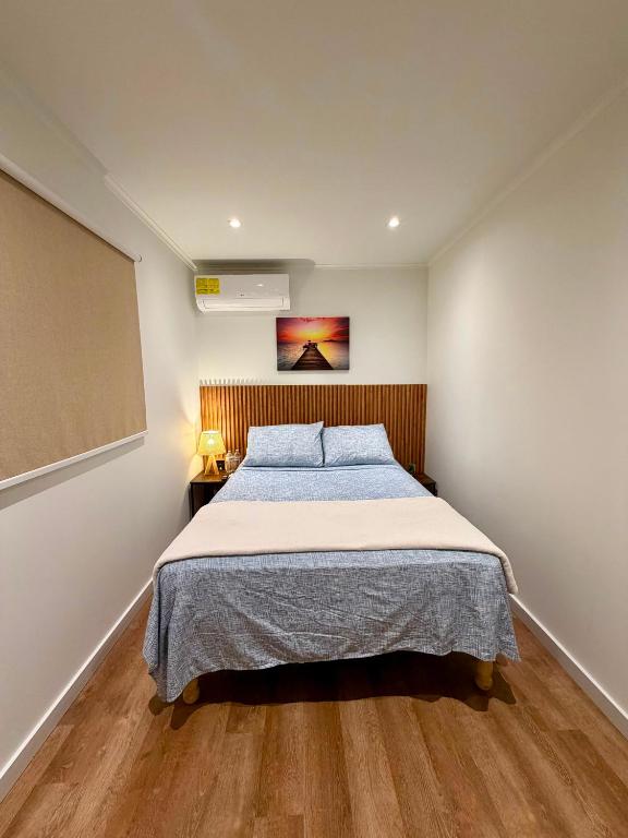 a bedroom with a bed and a painting on the wall at The Almas Container in Willemstad