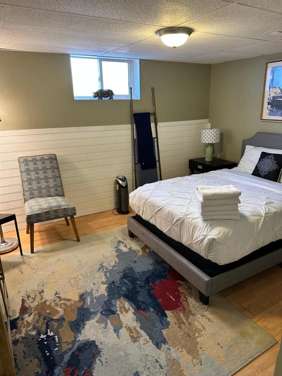 a bedroom with a bed and a chair and a rug at 1 Bedroom Basement Apartment Owen Sound in Owen Sound