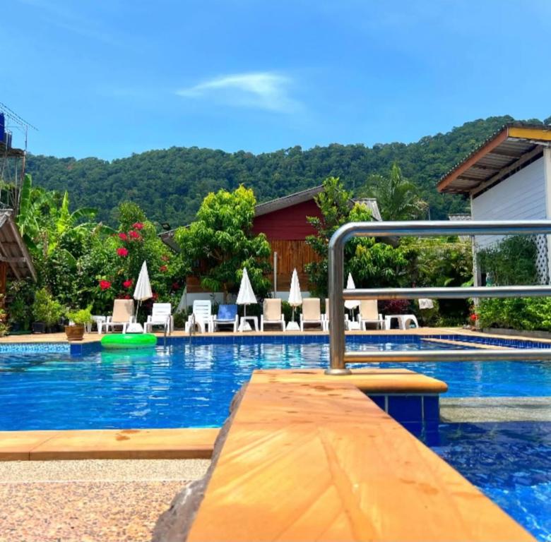 a swimming pool with a wooden ramp in a resort at Poonsap Resort in Ko Lanta