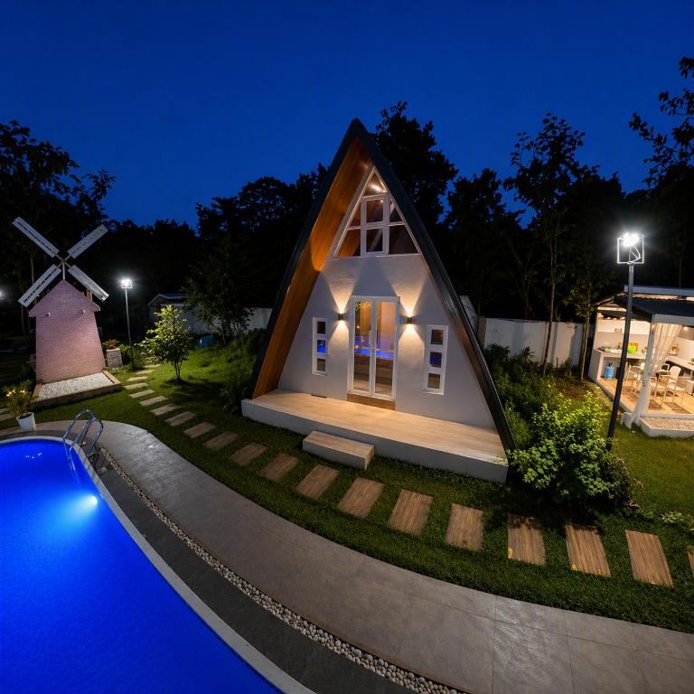 a small house with a pool and a windmill at The Siblings Farm House in Liliw