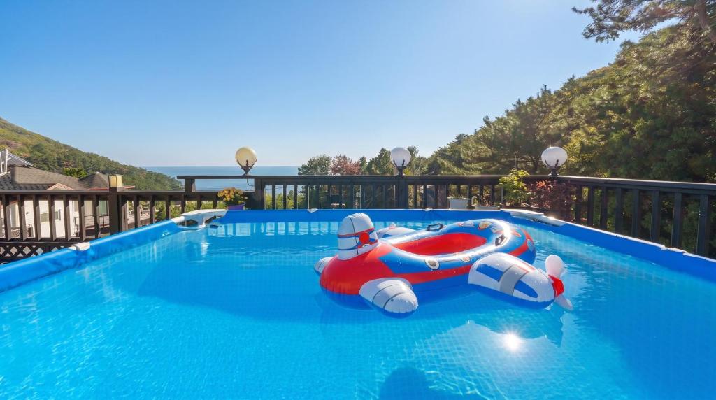 a pool with a red and white inflatable raft in it at geoje yeoul pet-friendly pension in Yŏch'a
