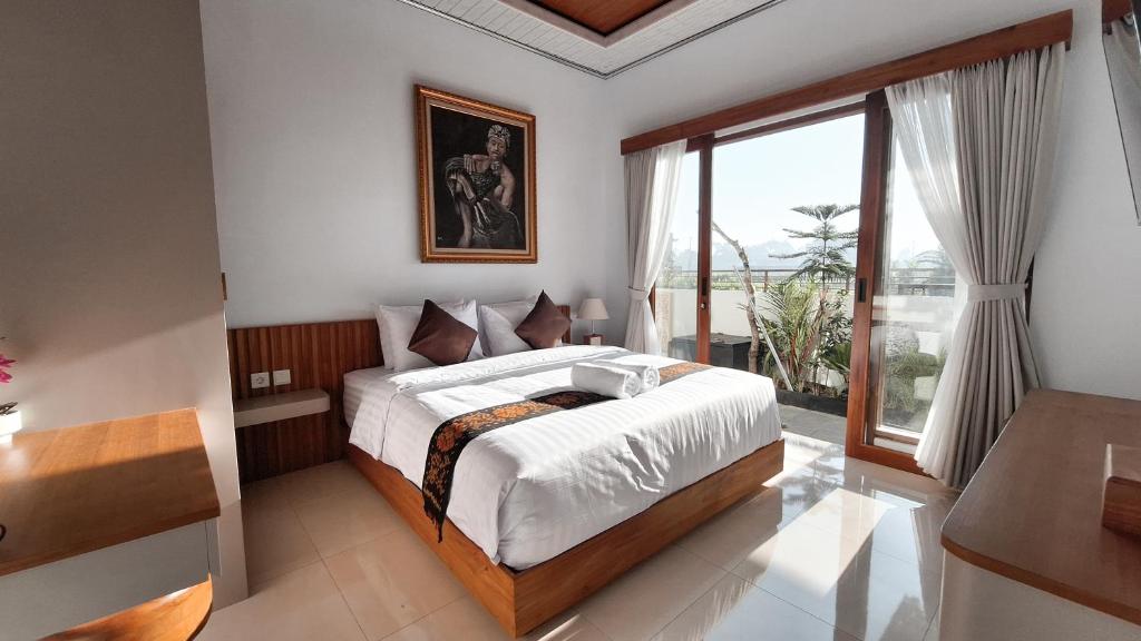 a bedroom with a bed and a large window at Villa Kasuri Bali in Blahbatu