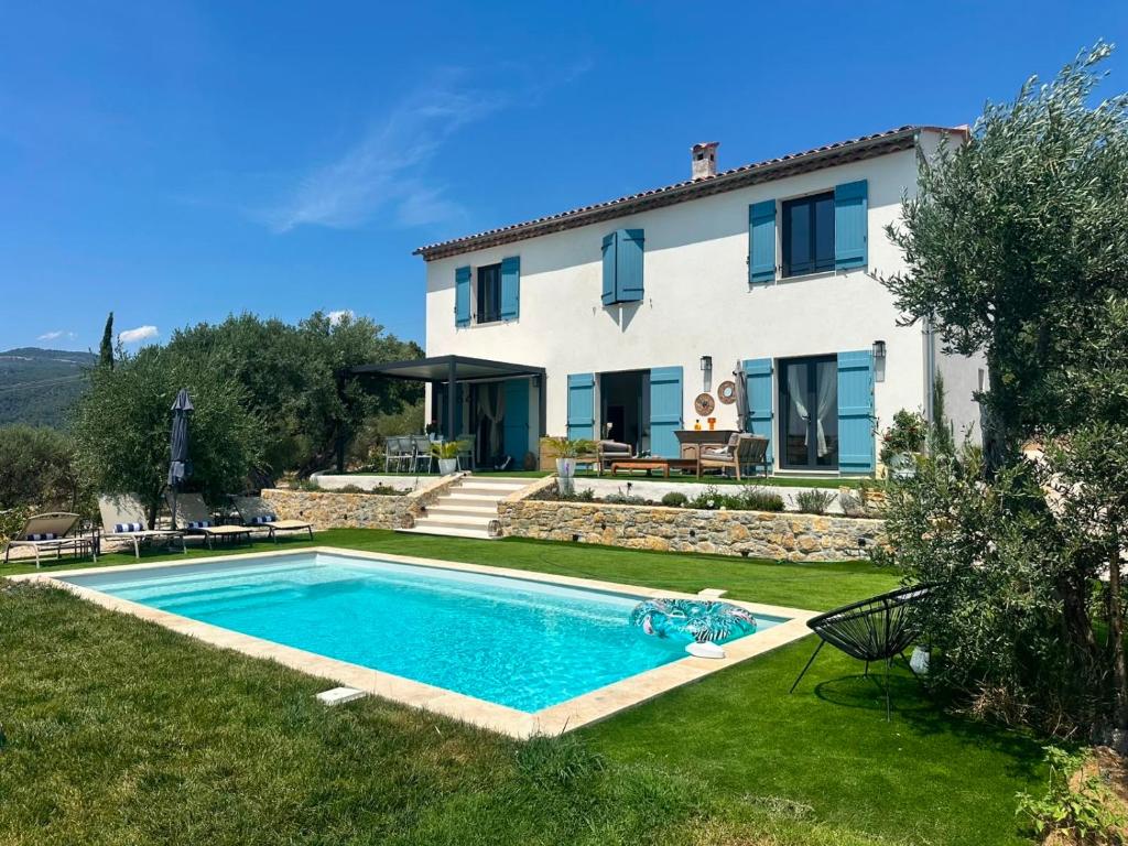a villa with a swimming pool in front of a house at Prestige villa Estrella in Fayence