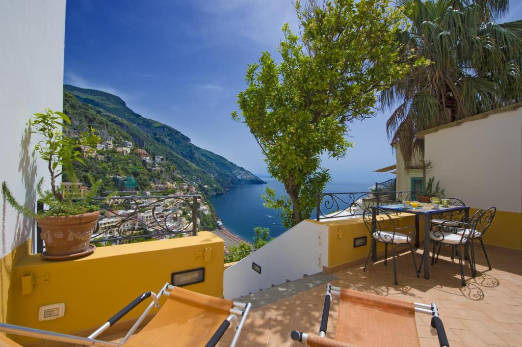 a balcony with a table and chairs and a view of the water at Casa Hellen Positano center in Positano