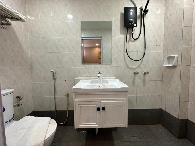 a bathroom with a sink and a toilet and a mirror at SS Grey Hotel in Kuala Lumpur
