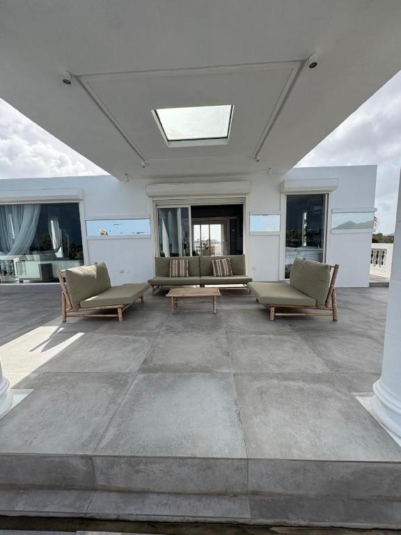 a living room with couches and a table and windows at FIG PARADIS the villa in Philipsburg