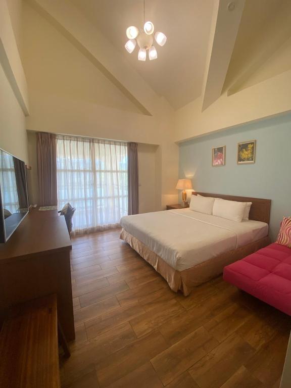 a bedroom with a bed and a red couch at He Sen B&B in Kenting